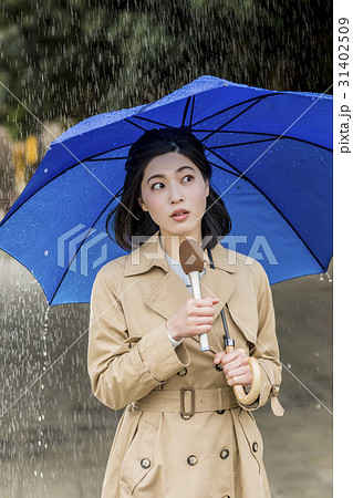 雨の降る街頭をリポートする女子アナ 31402509