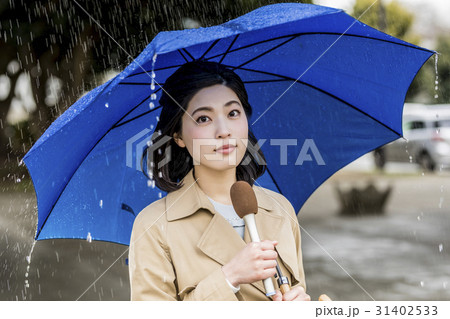 雨の降る街頭をリポートする女子アナ 31402533