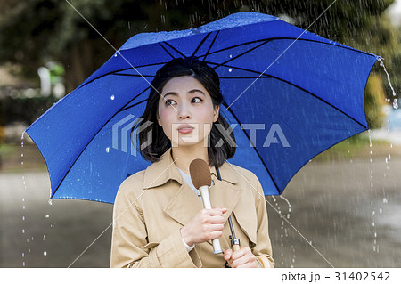 雨の降る街頭をリポートする女子アナ 雨の降る街頭をリポートする女子アナ 31402542