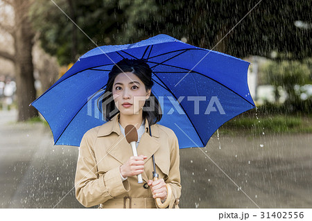 雨の降る街頭をリポートする女子アナ 31402556