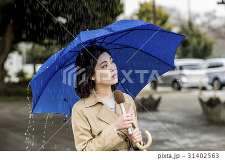 雨の降る街頭をリポートする女子アナ 雨の降る街頭をリポートする女子アナ 31402563