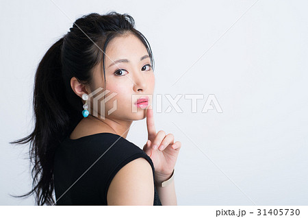 内緒ポーズをする若い女性の写真素材