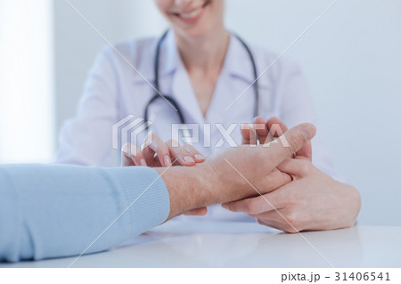 Helpful practitioner checking patient pulse in the Helpful practitioner checking patient pulse in the 31406541