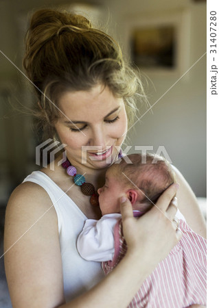 Young mother at home holding her newborn baby Young mother at home holding her newborn baby 31407280