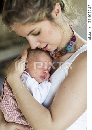 Young mother at home holding her newborn baby Young mother at home holding her newborn baby 31407282