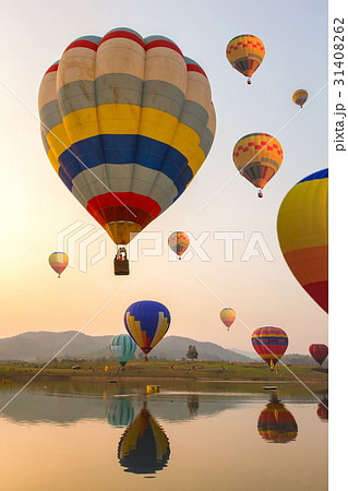Hot air color balloon over lake with sunset time 31408262
