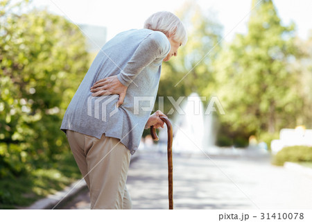Retired ill woman feeling backache in the park Retired ill woman feeling backache in the park 31410078