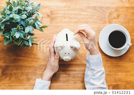 Woman holding a white piggy bank 31412231