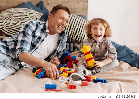Happy child sitting near his father on the bed 31412461