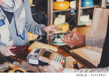 Customer paying for order of cheese in grocery Customer paying for order of cheese in grocery 31414615