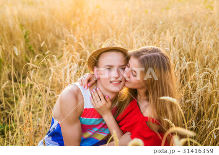 Young love couple kissing on field 31416359