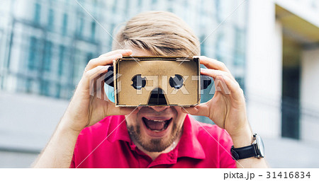 Funny man using cardboard virtual reality goggle 31416834