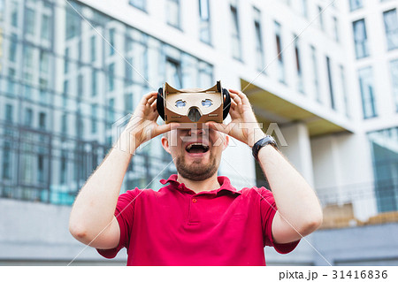 Funny man using cardboard virtual reality goggle 31416836