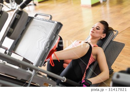 Fit young woman doing leg presses in the gym. Fit young woman doing leg presses in the gym. 31417021