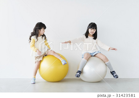 女の子2人 姉妹 ソファの写真素材