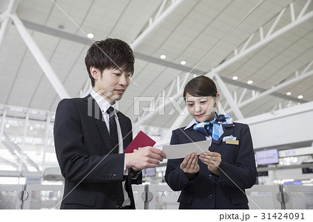 空港職員に質問をするビジネスマンの写真素材