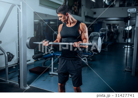 Tanned muscular man workout with barbell in gym 31427741