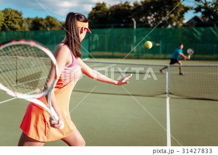 Couple playing tennis on outdoor court 31427833