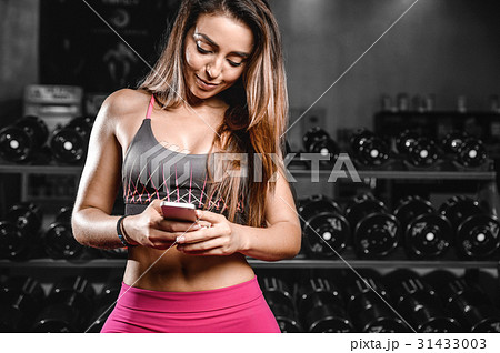 Pretty fitness girl with cellphone in gym. Sexy young woman Pretty fitness girl with cellphone in gym. Sexy young woman 31433003