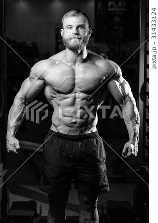 Handsome fit caucasian muscular man flexing his muscles in gym 31433124