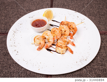 Delicious grilled shrimps on skewers. 31440894