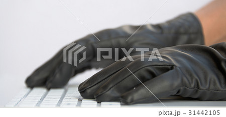 Hacker in black gloves on white computer keyboard 31442105