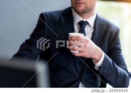 Stylish man in suit is drinking coffee Stylish man in suit is drinking coffee 31443414