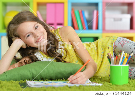 Little girl painting with pencil in her room  31444124
