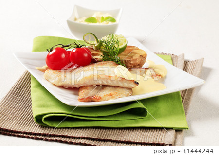 Skinless fish fillets with baked potato half 31444244