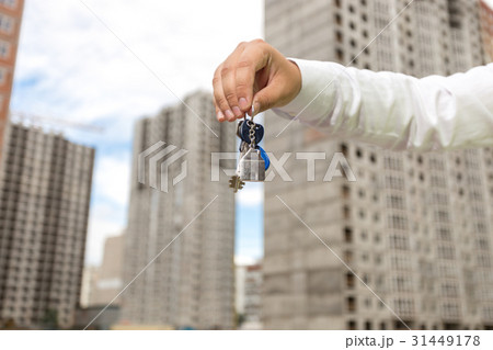 businessman holding keys in front of new building 31449178
