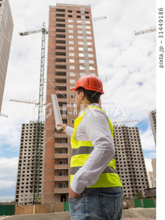 architect pointing with blueprints at building architect pointing with blueprints at building 31449186