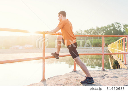 Fitness man stretching his leg muscles outdoors. 31450683