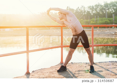 Young athlete man doing side bend exercise. 31450687