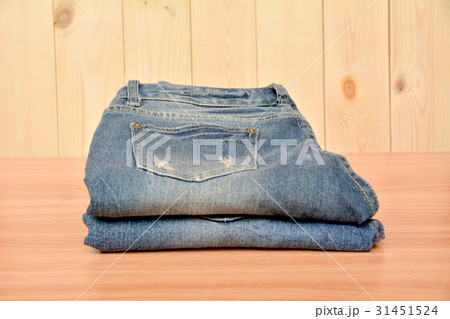 Blue jeans folded stack on wooden table on wooden 31451524