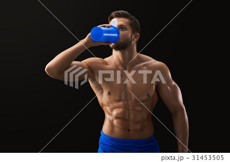 Shirtless ripped sportsman drinking after workout  31453505