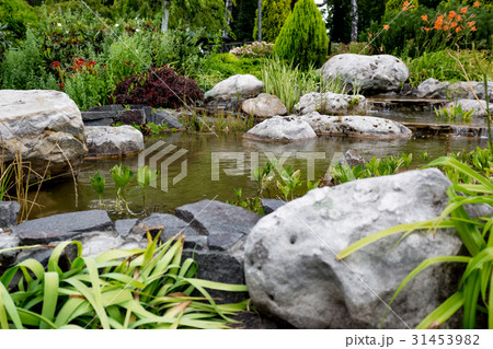 Water flowing through rocks in formal garden 31453982