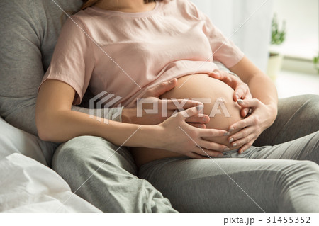 Young couple expecting baby relax on bed indoors Young couple expecting baby relax on bed indoors 31455352