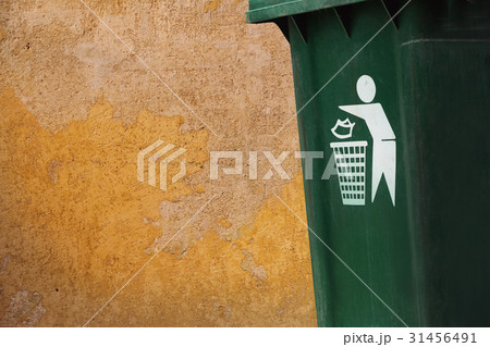 old green bins beside grunge yellow walls. 31456491
