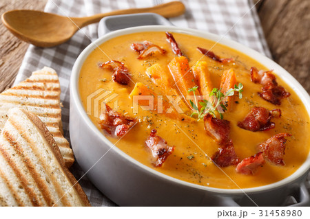 Sweet potato soup with bacon and herbs in a pan 31458980