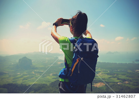 Woman hiker taking photo with smartphone  31462807