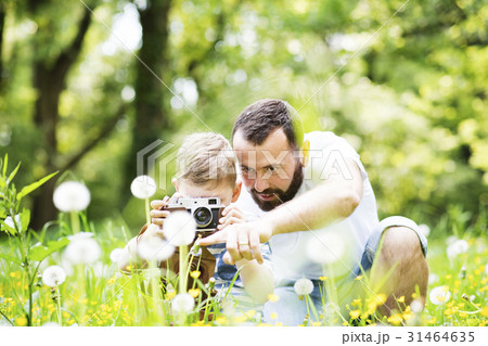 Young father with little boy with camera in summer Young father with little boy with camera in summer 31464635