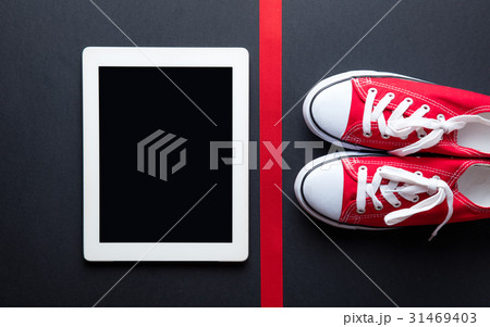tablet, gumshoes and ribbon 31469403