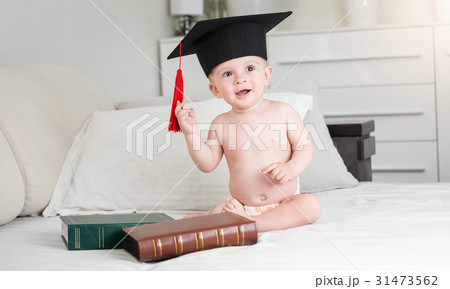 Funny baby in diapers wearing black graduation cap Funny baby in diapers wearing black graduation cap 31473562