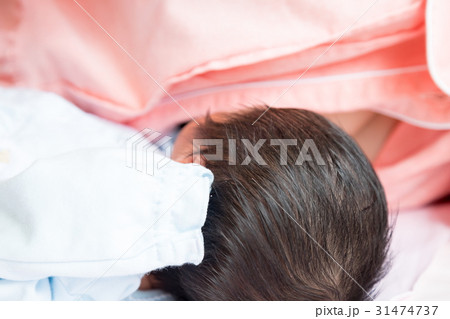 生後間もない赤ちゃんと授乳する母親　ママ　生まれたて乳児　産婦人科　個室　ベイビー　ベビー　ぼかし 31474737