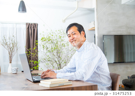パソコンを見る中年男性　ミドル世代　中高年　短髪の男性　カジュアル　普段着　男の人 31475253
