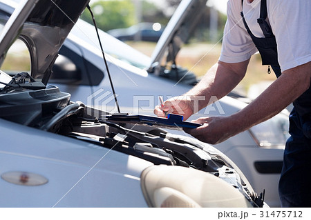 Auto mechanic checking car engine  31475712
