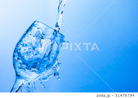 グラスから溢れる水の写真素材