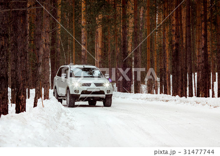SUV rides on a winter forest road 31477744