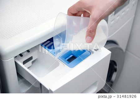 Woman hand pouring powder into the washing machine Woman hand pouring powder into the washing machine 31481926