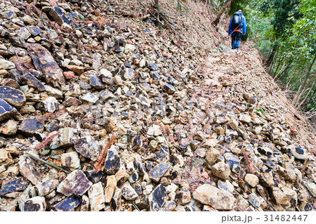 tourist walks on path through landslide 31482447